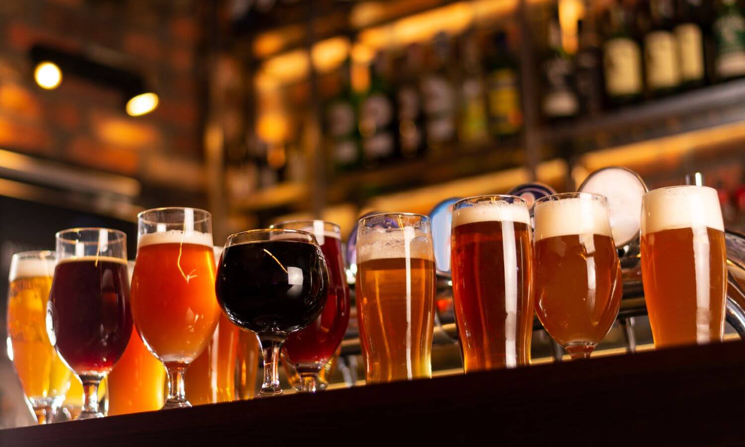 Several Mexican Craft Beers in glasses on a bar.