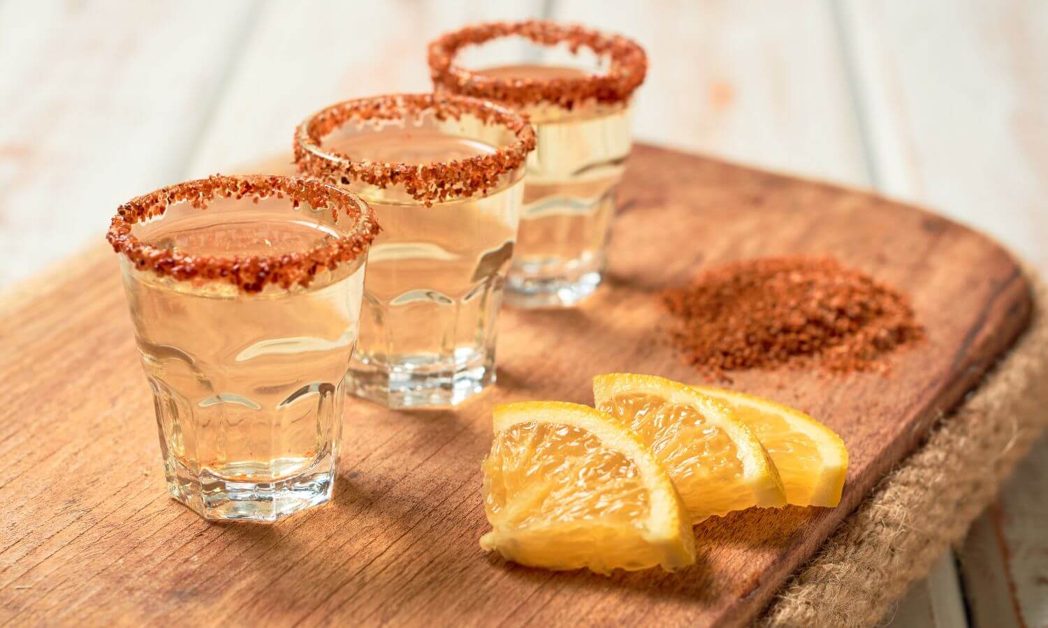 Mezcal shots rimmed with worm salt and served with orange slices.