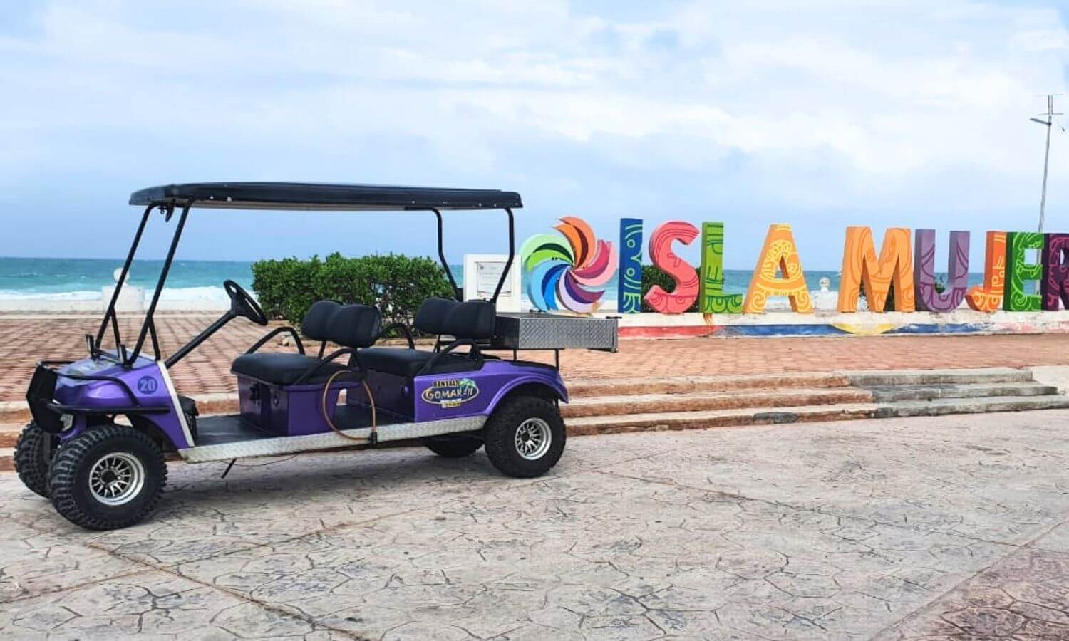 A Gomar II Golf Cart in front of the Isla Mujeres sign on the malecon.