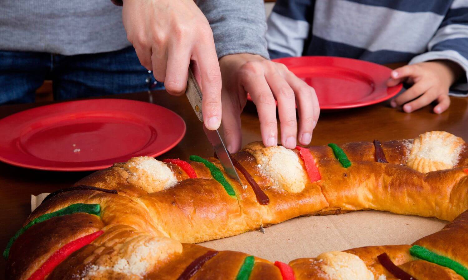 The traditional Christmas bread - Rosca del Reyes, being cut .