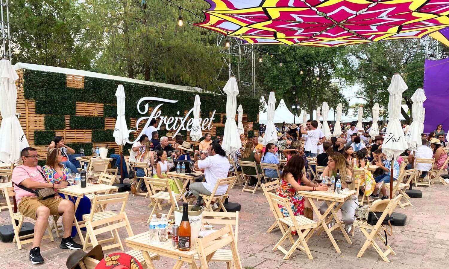 People sat sampling wine and food in front of the Freixenet booth at one of the Mexican Food and Wine Festivals