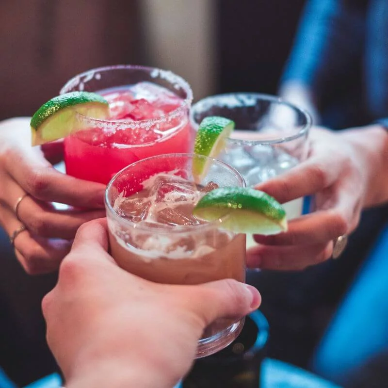 Origin Of The Margarita Cocktail Three flavors of margaritas being held by women.