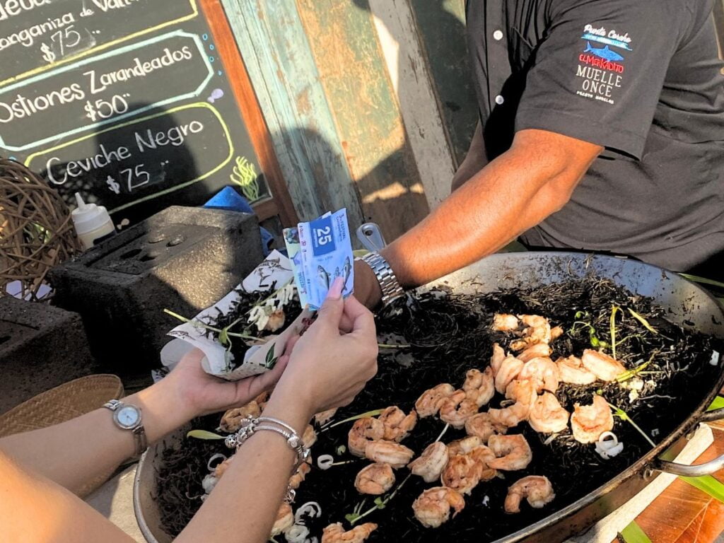 A guest handing over tickets for a portion of the delicious black ceviche.
