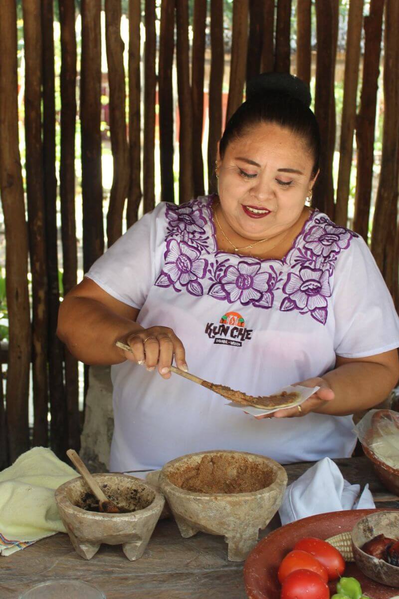 A woman making Sikil Pak from pumkin seeds at Kun Che park in Cozumel.