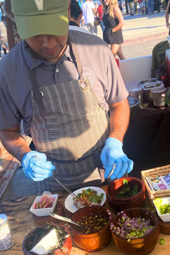 A man adding the final touches to a dish with tweezers.