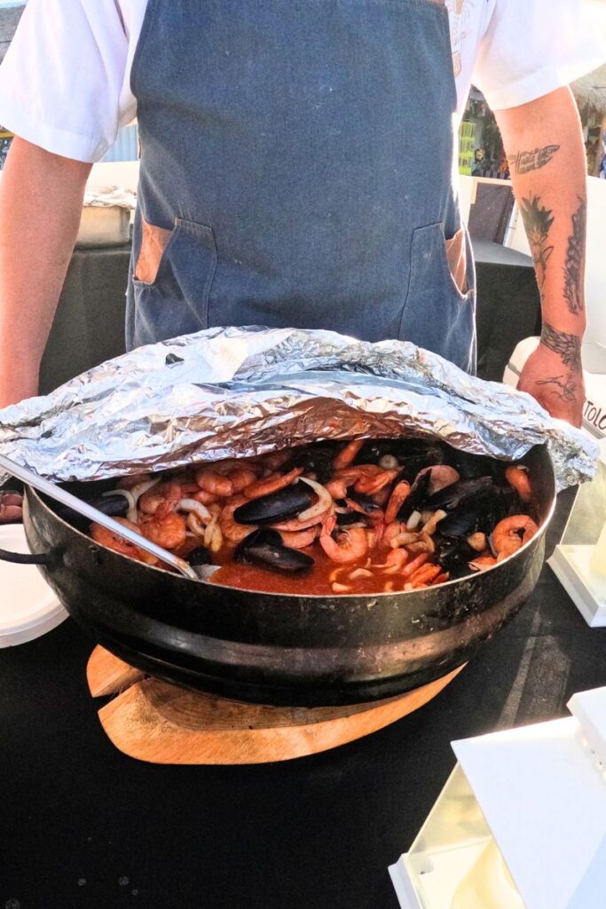 A huge pot of mixed shellfish in a broth.