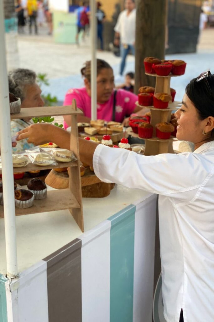 A woman selling cupcakes and desserts at the Puerto Morelos Mexican Caribbean Food festival.