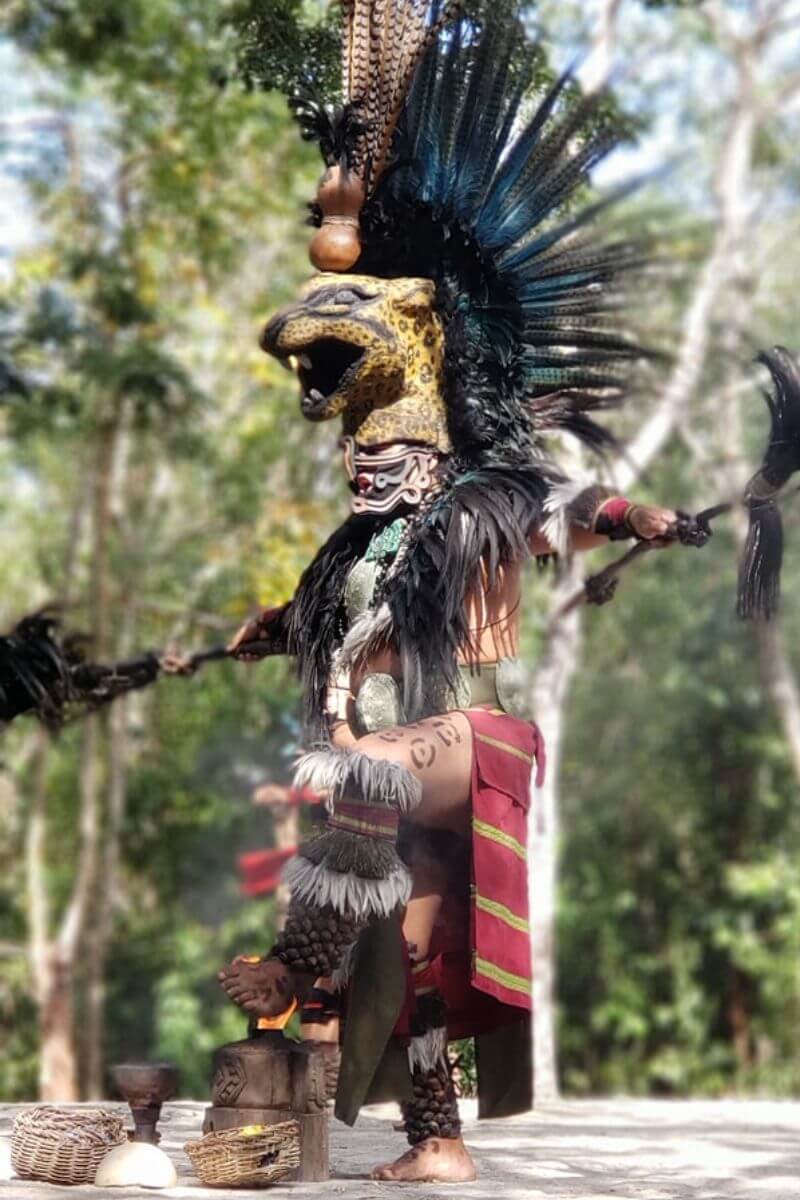A man in traditional Mayan dress with a jaguar headpiece at the Pueblo del Maiz Prehispanic show.