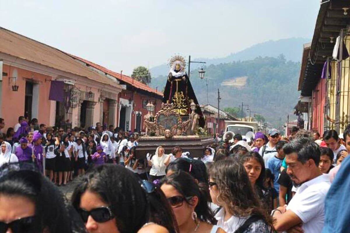 A Religious Procession through town with a float showing the Virgin Marry.