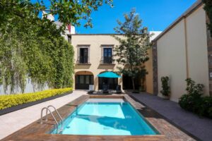 Home 3 Looking over a pool towards a property and tree. Where to stay in queretaro