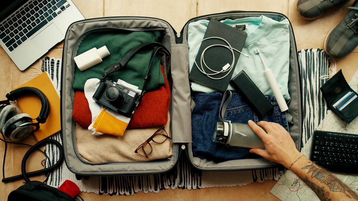 What To Pack For Cancun Man packing a suitcase for vacation